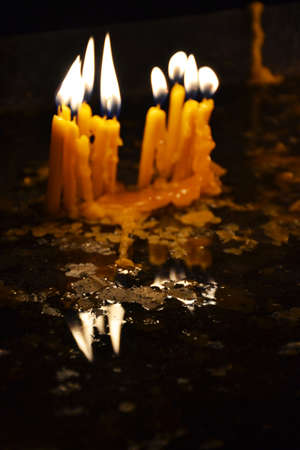 Burning candles in a church on a dark backgroundの写真素材