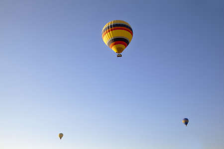 3 airborne balloons high in a clear blue skyの写真素材
