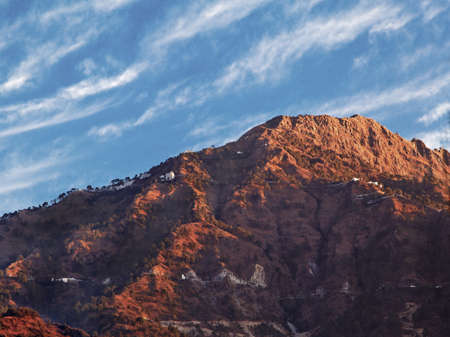 Landscape of dawn shadows and sunrays on Vaishnoo Devi at the foothills of Himalayas from Katra,...