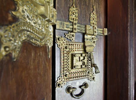 portrait craftsmanship of ornate brass door furniture and detailing in Kerala India