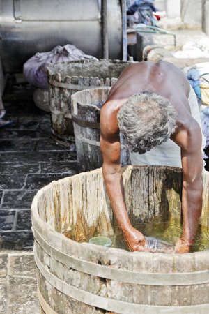 Dhobhi Ghat Mumbai man at work washing commercial dirty laundry in Oak Vatsのeditorial素材