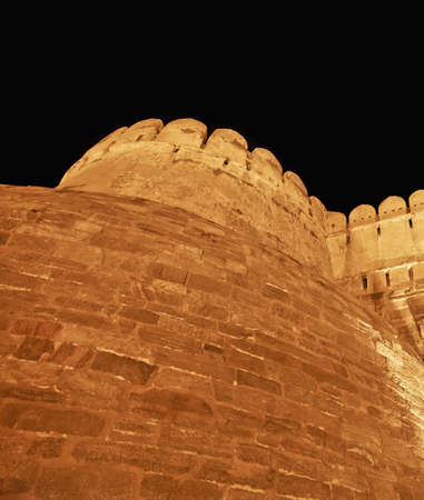 Street lights light up the fortification and bastions of Kumbhalghar Fort, India and night timeのeditorial素材