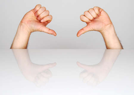 two hands showing the gesture of defeat
