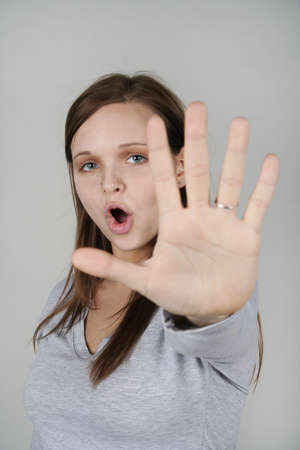 Young woman holding out her hand and screaming,  NO  の写真素材