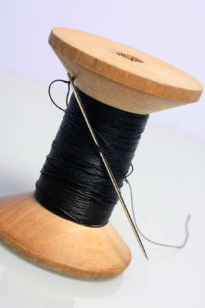 Spool of black thread on white background 