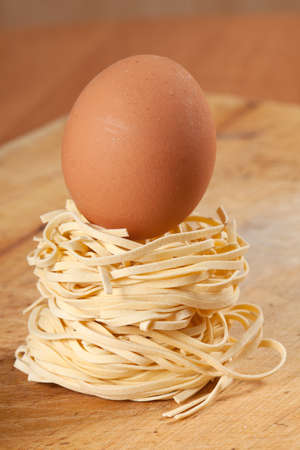 Nests of dry pasta on wooden table.の写真素材