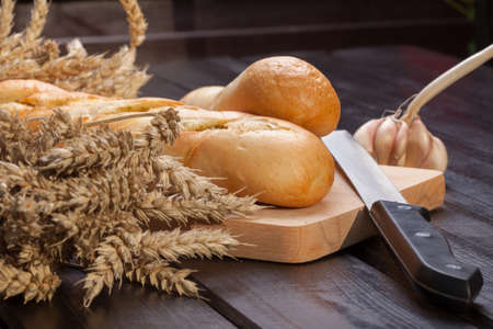 Baguettes lying on a wooden chopping board.