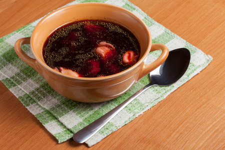 Red borscht with ravioli on a wooden board.の写真素材