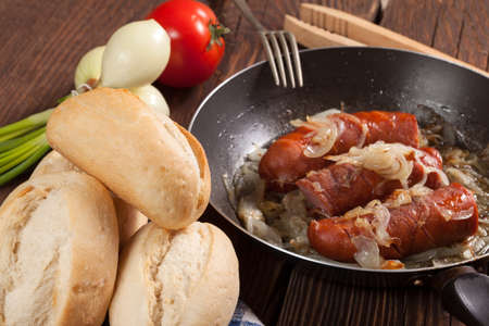 Fried sausage with onions in the pan の写真素材