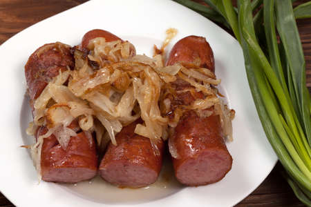 Fried sausage with onions on a plate の写真素材