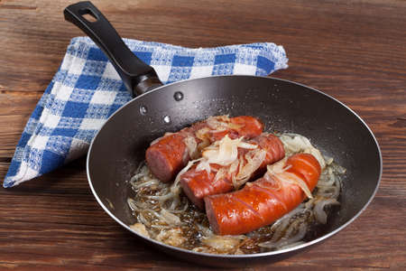 Fried sausage with onions in the pan.の写真素材