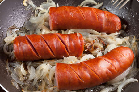 Fried sausage with onions in the pan.の写真素材