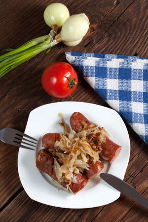 Fried sausage with onions on a plate.の写真素材