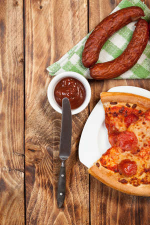 Two pieces of pizza with topping on a wooden table.の写真素材