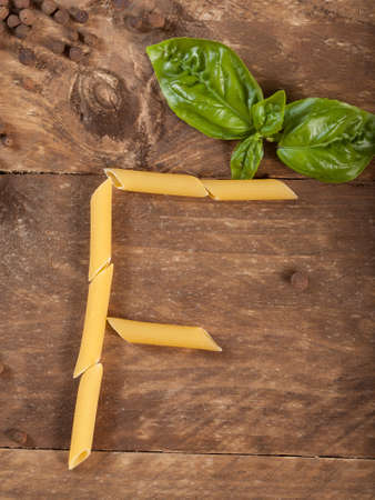 The letter F with pasta on a wooden table.の写真素材