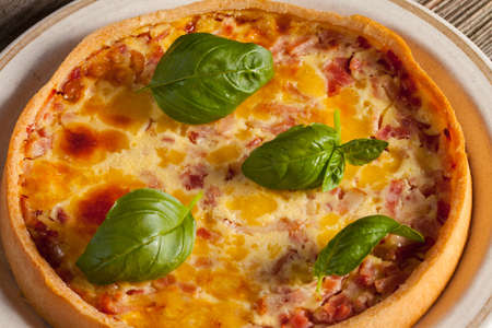 Tart with ham and bacon on aplate.