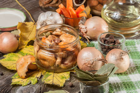 Delicious marinated mushrooms, oil and spices on wooden table. Selective focus.の写真素材