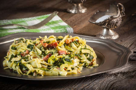 Spaghetti with spinach and bacon on a wooden table. Selective focus.の写真素材