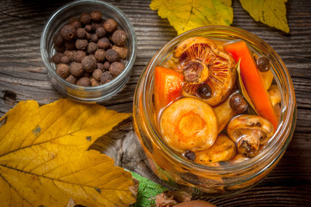 Delicious marinated mushrooms, oil and spices on wooden table. Selective focus.の写真素材
