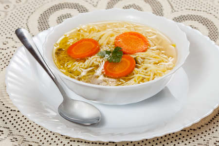 Broth - chicken soup with noodles on a plateの写真素材