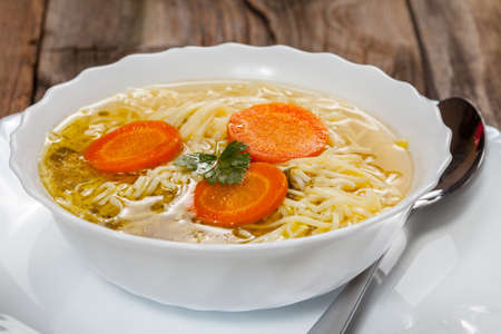 Broth - chicken soup with noodles on a plateの写真素材