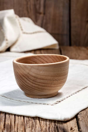 Wooden bowl on a linen tablecloth.の写真素材