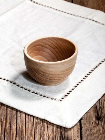 Wooden bowl on a linen tablecloth.の写真素材