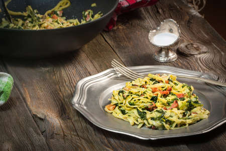 Spaghetti with spinach and bacon on a wooden table. Selective focus.の写真素材