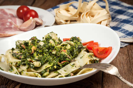 Spaghetti with spinach and bacon on a wooden table. Selective focus.の写真素材