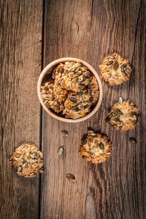 Cookies with pumpkin seeds and cinnamon on a wooden background. Selective focus.の写真素材