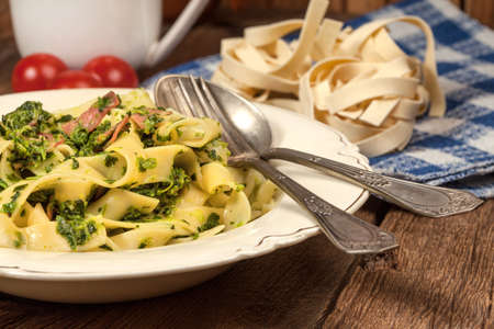 Spaghetti with spinach and bacon on a wooden table. Selective focus.の写真素材