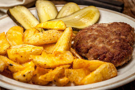 Fried chop, french fries and cucumber. Selective focus.の写真素材