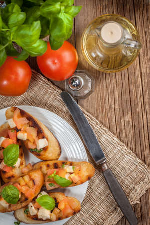 Appetizer bruschetta with roasted tomatoes, mozzarella cheese, garlic and basil.の写真素材