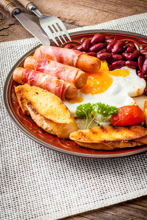 Full Angielski breakfast with bacon sausage fried egg and baked beans.の写真素材