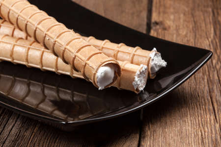 Sweet tube with whipped cream. Selective focus.