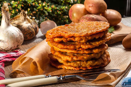 Fried potato pancakes pile on a wooden table.の写真素材
