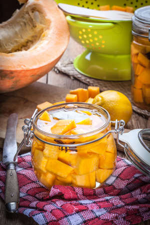 Pumpkin pickle in a glass container on a wooden table.の写真素材