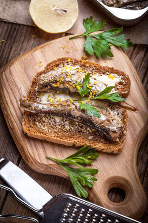Sandwich with sprats with parsley and lemon.の写真素材