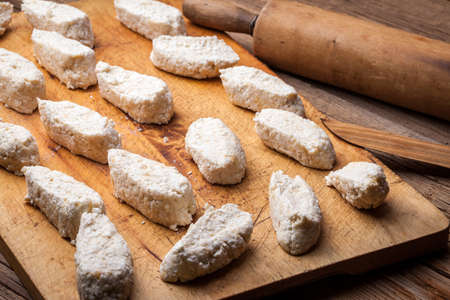 Uncooked homemade noodles lazy has a wooden pastry board.の写真素材