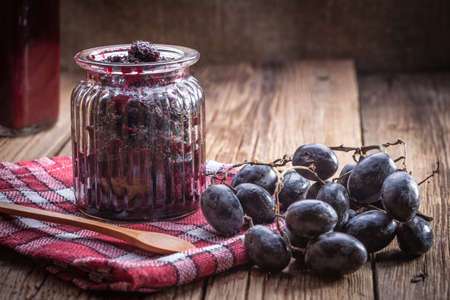 Dark grape jam on a wooden table.の写真素材