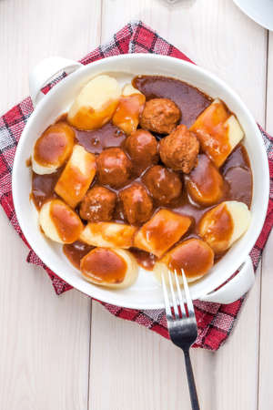 Potato dumplings with meat meatballs in gravy.