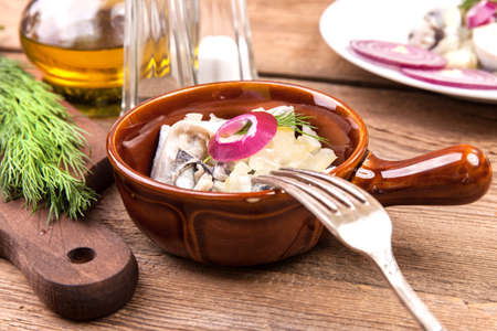 Tasty herring in pieces on a wooden table.の写真素材
