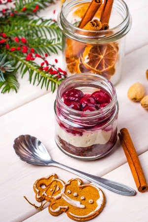 Layered dessert with fruits, nuts and cream cheese in glass jar.