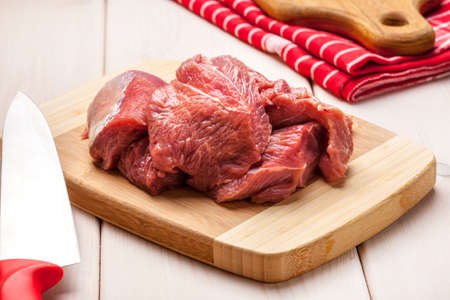 Raw turkey in pieces on a bamboo board.