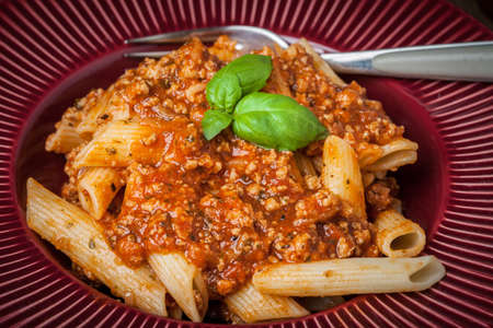Penne a bolognese on white plate. Shallow depth of field.の写真素材