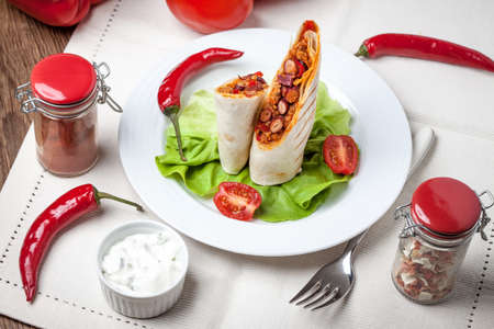 Burritos wraps with meat, beans and vegetables on wood board. Shallow depth of field.の写真素材