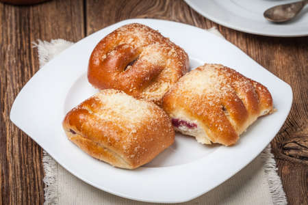 Buns with berries on a wooden table. Shallow depth of field.の写真素材