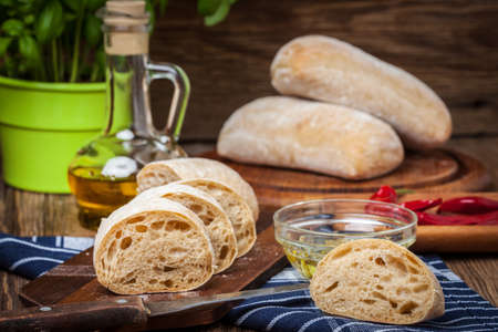 Sliced ciabatta bread on cutting board. Selective focus.