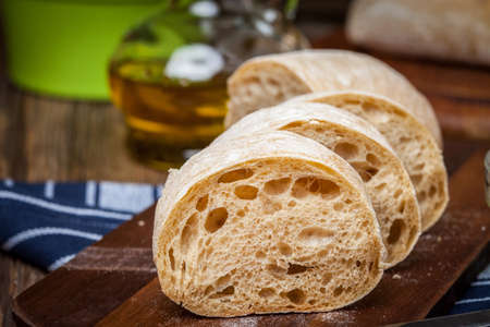 Sliced ciabatta bread on cutting board. Selective focus.