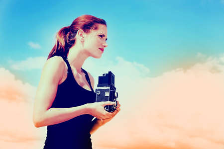 Young girl photographer on a sunny beach.の写真素材